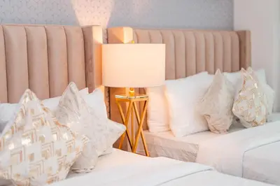 a bedroom with two beds with pillows and a lamp at Elite Royal Apartment - Highest Floor - Full Burj Khalifa & Fountain View - Duke in Dubai