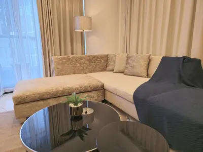 a living room with a couch and a glass table at Quill Residence at Paramount Towers 3 BR Creek View in Dubai