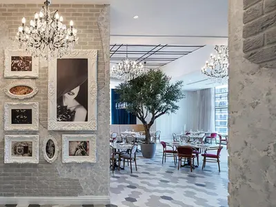 a dining room with tables and chairs and chandeliers at Paramount Midtown -Stunning 2 Bedroom Apt with Burj-Khalifa view in Dubai