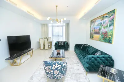 a living room with a couch and a tv at Paramount Midtown -Stunning 2 Bedroom Apt with Burj-Khalifa view in Dubai
