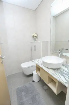 a white bathroom with a sink and a toilet at Paramount Midtown -Stunning 2 Bedroom Apt with Burj-Khalifa view in Dubai