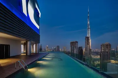 a swimming pool on top of a building with a city skyline at Paramount Midtown -Stunning 2 Bedroom Apt with Burj-Khalifa view in Dubai