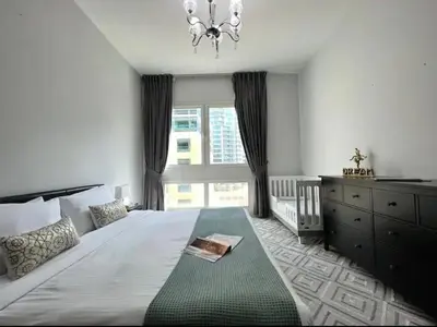 a bedroom with a large bed with a chandelier and a window at Dubai marina sail in Dubai