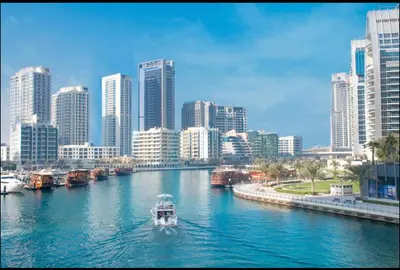 a white boat in a river in a city at Dubai marina sail in Dubai