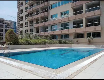 a swimming pool in front of a building at Dubai marina sail in Dubai