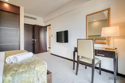 a hotel room with a bed and a desk and a mirror at Pristine 1BR in The Address Residences Dubai Marina by Deluxe Holiday Homes in Dubai
