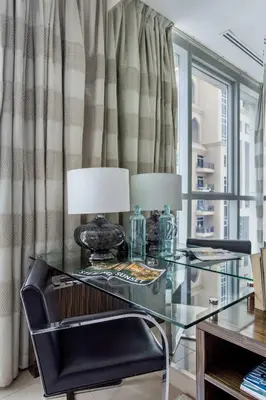 a glass table with two lamps and a chair at Frank Porter - Bonnington in Dubai