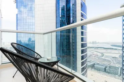a chair in a room with a view of a city at GlobalStay DAMAC Towers by Paramount Business Bay Apartments in Dubai