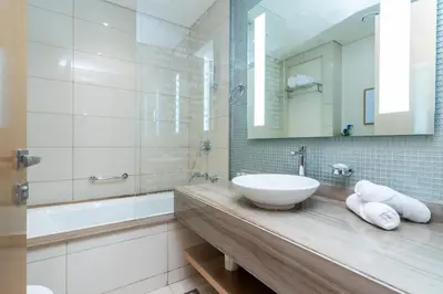 a white bathroom with a sink and a mirror at GlobalStay DAMAC Towers by Paramount Business Bay Apartments in Dubai
