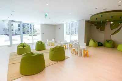 a room with green chairs and tables and a tree at Frank Porter - Creek Horizon T2 in Dubai