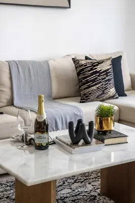 a white coffee table with a bottle of wine and glasses at Frank Porter - Creek Horizon T2 in Dubai