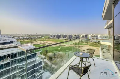 a balcony with a table and chairs on a building at Sunlit Studio at Golf Promenade 2A DAMAC Hills By Deluxe Holiday Homes in Dubai