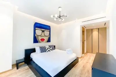 a bedroom with a bed with a painting on the wall at Designer apartment on the Marina Walk in Dubai