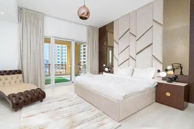 a bedroom with a large bed and a chair at Ahlan HH - Luxurious Apartment with Beach Access and Sea View at Palm Jumeirah in Dubai