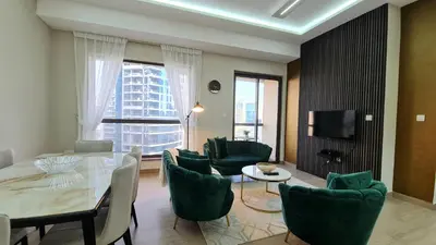 a living room with a table and chairs and a tv at Marco Polo - Experience beachfront luxury at Bahar 6 JBR in Dubai