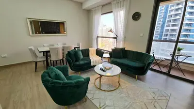 a living room with green chairs and a table at Marco Polo - Experience beachfront luxury at Bahar 6 JBR in Dubai