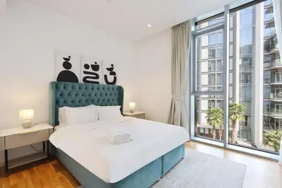 a bedroom with a large bed and a large window at Livbnb - Tranquil 2BR in Bluewaters in Dubai