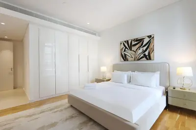 a white bedroom with a large white bed with white pillows at Livbnb - Tranquil 2BR in Bluewaters in Dubai