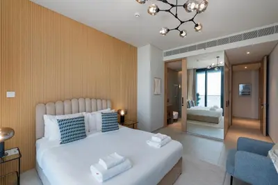 a bedroom with a large white bed and a blue chair at Address JBR Sea View, Jumeirah Beach Residence, Dubai Marina - Mint Stay in Dubai