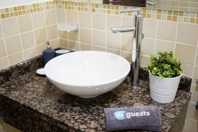 a bathroom with a bowl sink and a plant on a counter at HiGuests - Charming Apt in JBR with Balcony by the Beach in Dubai