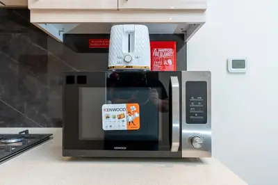 a bottle of wine sitting on top of a microwave at White Sage - Elite Residence Studio in Dubai