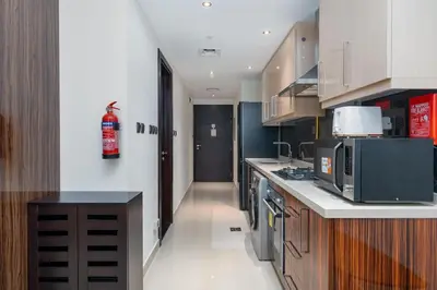 a kitchen with a microwave and a stove top oven at White Sage - Elite Residence Studio in Dubai