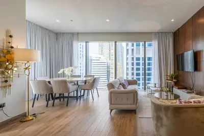 a living room with a table and chairs and a dining room at Luxury 2BD apartment in MarinaGate Jumeirah Living in Dubai