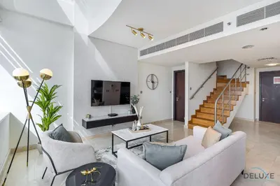 a living room with a couch and a tv at Refreshing 1BR Loft At Sky Garden DIFC By Deluxe Holiday Homes in Dubai