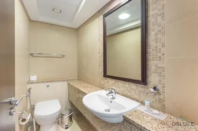 a bathroom with a sink and a toilet and a mirror at Refreshing 1BR Loft At Sky Garden DIFC By Deluxe Holiday Homes in Dubai