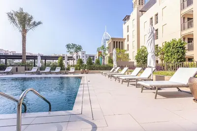 a swimming pool with lounge chairs next to a building at Luxury 1BD apartment in Madinat Jumeirah Living in Dubai