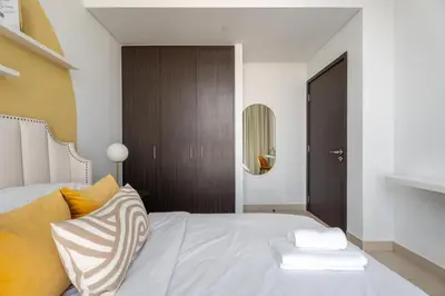 a bedroom with a bed with yellow and white pillows at GuestReady - Luxury Tower with Burj Khalifa View in Dubai