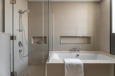 a bathroom with a bath tub and a shower at GuestReady - Luxury Tower with Burj Khalifa View in Dubai