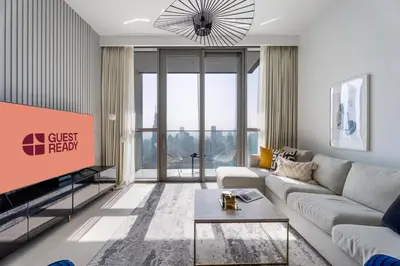 a living room with a couch and a tv at GuestReady - Luxury Tower with Burj Khalifa View in Dubai
