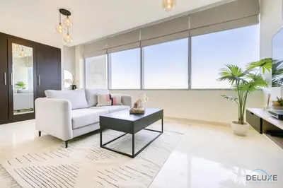 a living room with a white couch and a table at Calm Studio at Sky Gardens DIFC by Deluxe Holiday Homes in Dubai