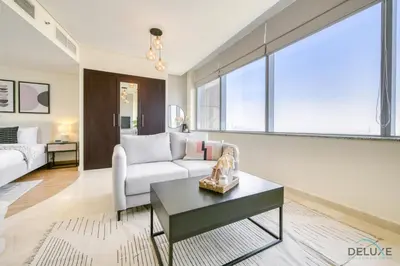 a living room with a couch and a table at Calm Studio at Sky Gardens DIFC by Deluxe Holiday Homes in Dubai