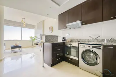 a kitchen with a washer and a dishwasher at Calm Studio at Sky Gardens DIFC by Deluxe Holiday Homes in Dubai