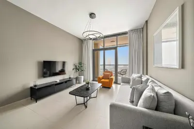 a living room with a couch and a tv at Silkhaus Burj Khalifa view large 2BDR in great location in Dubai