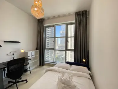 a bedroom with a bed and a desk and a window at Lux BnB Standpoint Tower Burj & Fountain Views in Dubai