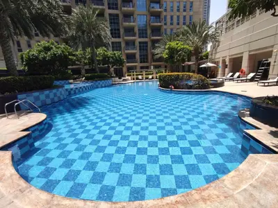 a large swimming pool with blue tiles in a building at Lux BnB Standpoint Tower Burj & Fountain Views in Dubai