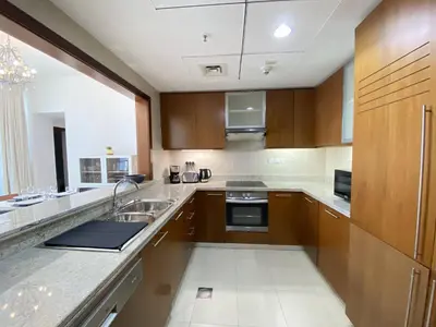 a large kitchen with wooden cabinets and a sink at Lux BnB Standpoint Tower Burj & Fountain Views in Dubai