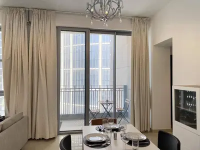 a living room with a table and a large window at Lux BnB Standpoint Tower Burj & Fountain Views in Dubai
