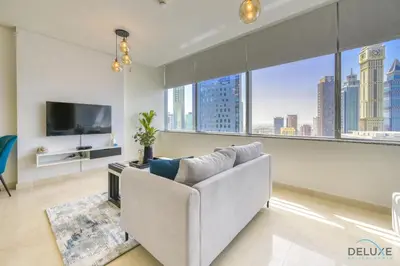 a living room with a couch and a large window at Welcoming Studio at Sky Gardens DIFC By Deluxe Holiday Homes in Dubai