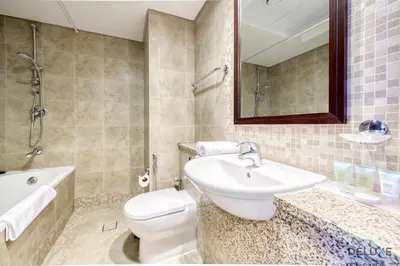 a bathroom with a sink and a toilet and a tub at Welcoming Studio at Sky Gardens DIFC By Deluxe Holiday Homes in Dubai