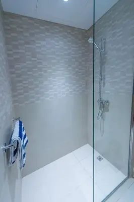 a bathroom with a shower with a glass door at Luxury Escapes - Cozy Studio In front of Metro Stn - Access to Gym & Pool - Aura Azizi in Dubai