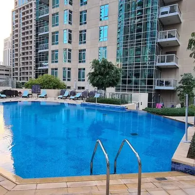 a large blue swimming pool in front of a building at FIRST CLASS 3BR with full BURJ KHALIFA VIEW in Dubai