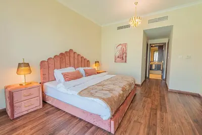 a bedroom with a large bed with a wooden headboard at FIRST CLASS 3BR with full BURJ KHALIFA VIEW in Dubai