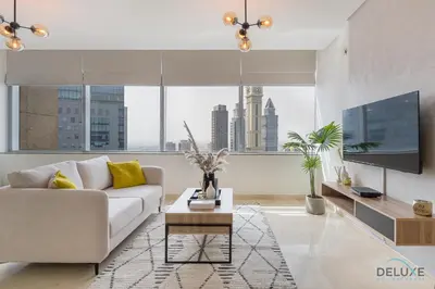 a living room with a couch and a tv at Sunny Studio at Sky Gardens DIFC by Deluxe Holiday Homes in Dubai