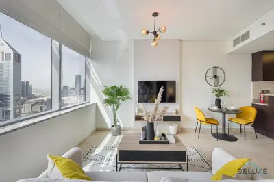a living room with a couch and a table at Sunny Studio at Sky Gardens DIFC by Deluxe Holiday Homes in Dubai