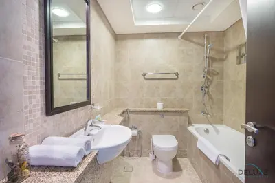 a bathroom with a sink and a toilet and a tub at Sunny Studio at Sky Gardens DIFC by Deluxe Holiday Homes in Dubai