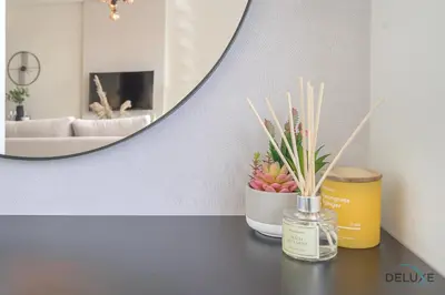 a table with a bottle of perfume and a mirror at Sunny Studio at Sky Gardens DIFC by Deluxe Holiday Homes in Dubai